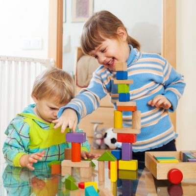 siblings together playing with  toys in home